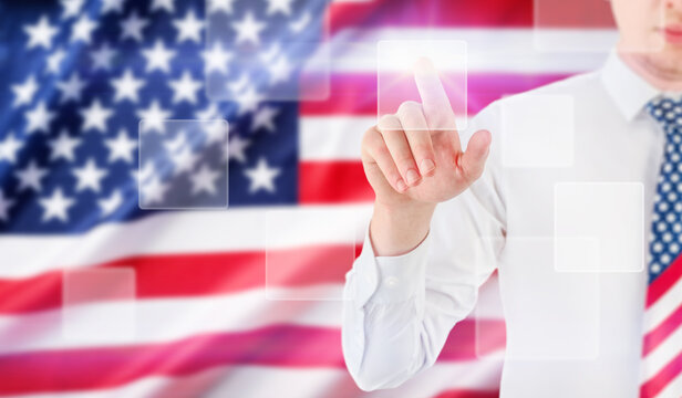 Man in a patriotic necktie touches a glowing interface before an American flag
