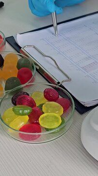 Analyzing candy samples under a microscope in a laboratory setting