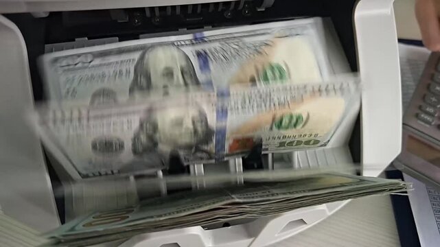 Counting cash in a currency counting machine in a busy office