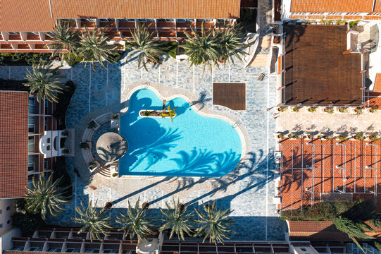 Resort hotel complex with swimming pool and palm tree shadows in Agia Napa, Cyprus