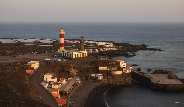 Vista a&eacute;rea lejana de los faros de Fuencaliente, las salinas, la peque&ntilde;a cala de arena negra y el caser&iacute;o de pescadores al atardecer en La Palma.