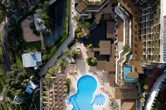 View of a luxury hotel complex with swimming pool, gardens, and sun loungers in Limassol