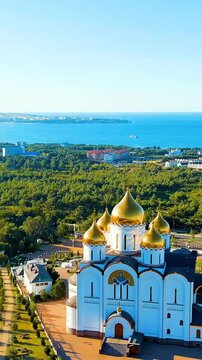 Vertical video. Gelendzhik, Russia. Cathedral of St. Andrew the First-Called. The text along the M4-Don Highway is translated: Glory to Russia, Kuban-Pearl of Russia. Gelenzhik-City Resort. Drone foo