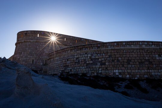 A sunstar shines over Castillo de San Felipe at Los Escullos in Cabo de Gata-N&iacute;jar Natural Park, Almer&iacute;a, Spain
