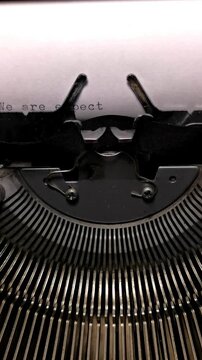 Vertical Macro Shot of Vintage Typewriter Typing the Words We Are Expecting