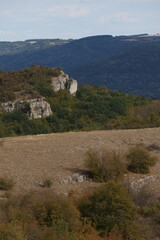 Fototapeta premium Vertical landscape of rocky cliffs and rolling green hills