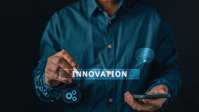 Businessman using a stylus pen to write the word innovation with artificial intelligence and gear icons on a virtual screen, symbolizing modern business creativity and technological strategy.
