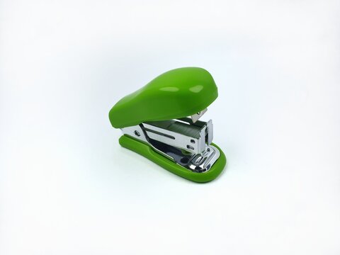 Close up of green mini stapler isolated on a clean white background. Side view.