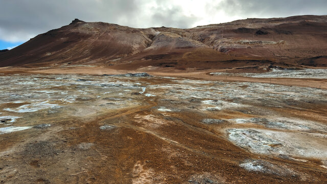 Mars-like landscape in an Icelandic geothermal area, with colorful mineral ground, steam vents and barren volcanic terrain.