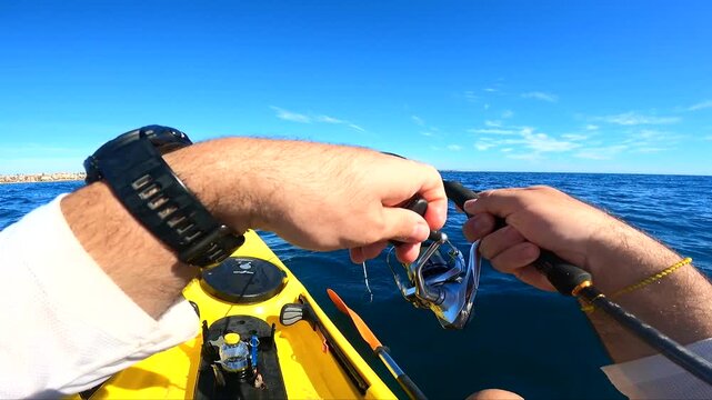 POV shot of fisherman holding bent rod fighting serviola amberjack on kayak