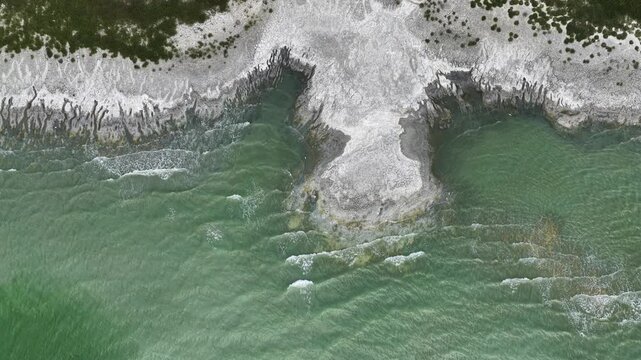 An aerial view of the white, salty soil exposed as the water level in Lake Burdur receded due to drought, and the waves crashing against the shore.