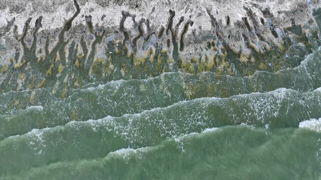 An aerial view of the white, salty soil exposed as the water level in Lake Burdur receded due to drought, and the waves crashing against the shore.