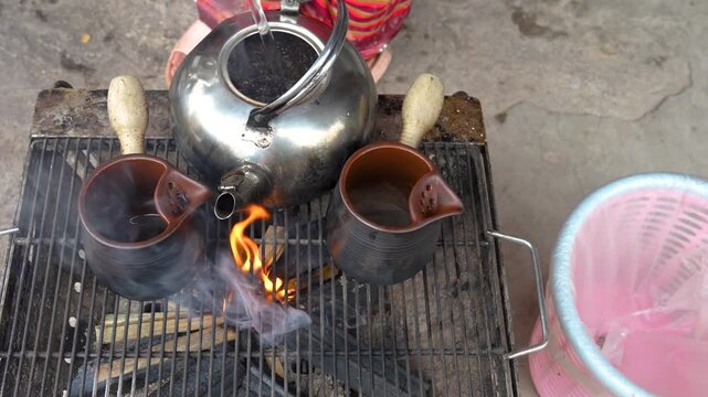 Traditional Coffee Brewing on Charcoal Stove with Metal Kettle and Clay Pots