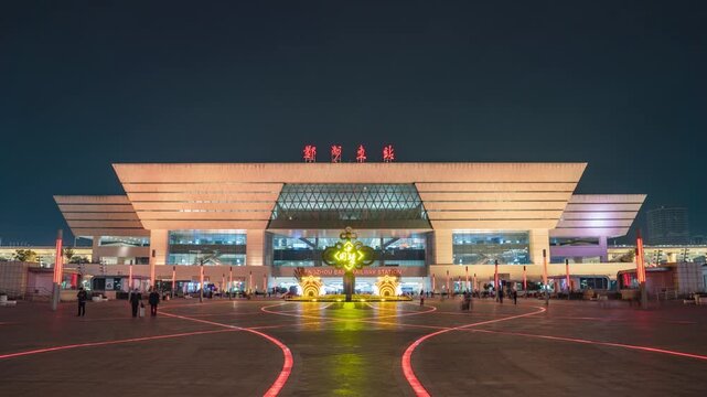 Illuminated Zhengzhou East Railway Station at Night with Red Light Trails in Zhengzhou East Railway Station, Zhengzhou, China