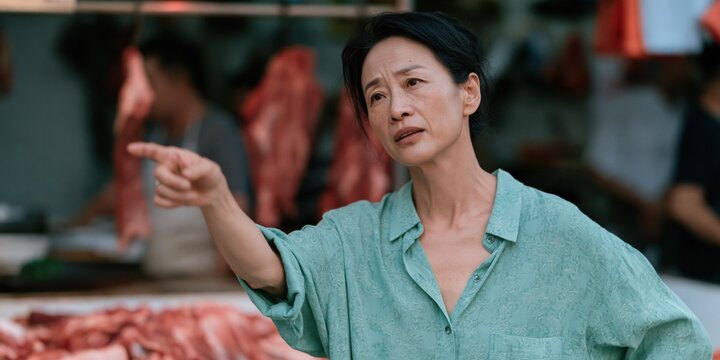 Middle aged woman pointing and arguing at a meat market stall with vendor during shopping interaction for retail complaint or customer service scene