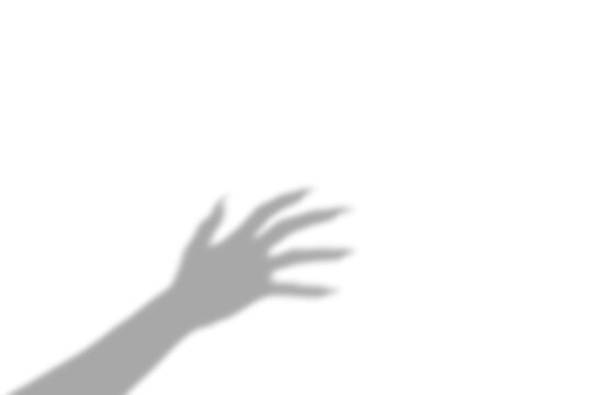 A dark spooky shadow of a human hand with long fingers reaching out in a creepy gesture presented as an isolated on transparent background