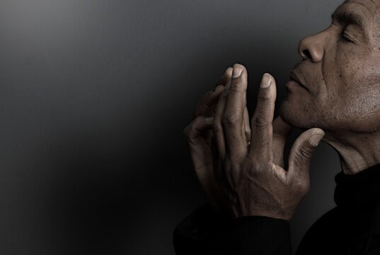 A serene portrait of a man praying with hands together in deep prayer that perfectly captures themes of faith, hope, mindfulness, and inner peace stock image stock photo