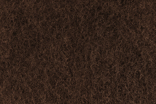 Abstract brown felt texture with dense fibers, fluffy structure of carpeting or artificial grass close up, macro. Textile surface, material for sports flooring, backgrounds, upholstery and design