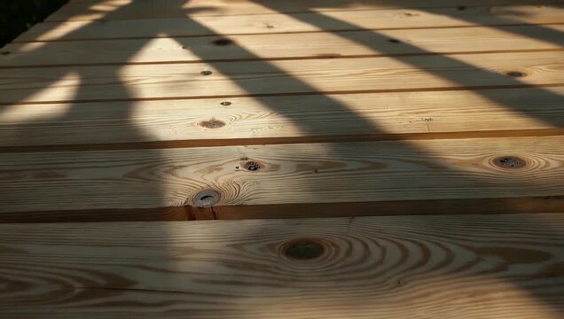 Serene 4K Ultra HD texture video showing warm sunlight casting leafy foliage shadows across a textured wooden panel accentuating natural wood grain patterns for interior design and relaxing