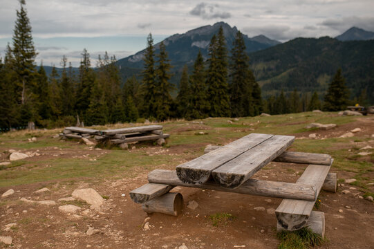 Rustic wooden picnic tables on a scenic mountain meadow in the Tatra National Park of Poland