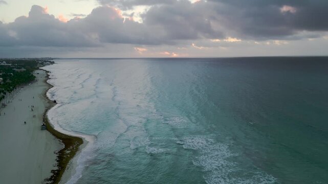 Aerial view of a tranquil coastline meeting turquoise waves at dusk