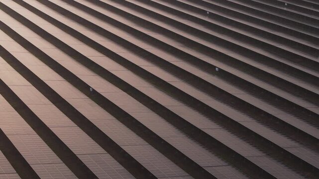 Extreme close-up aerial shot of repeating parallel rows of photovoltaic solar panels
