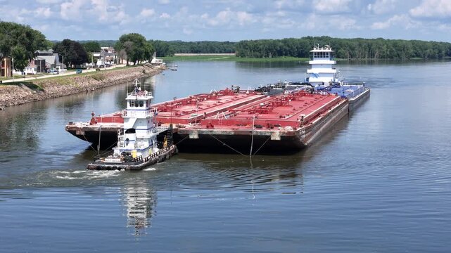 Two tug boats positioning a set of liquid barges on the Mississippi River