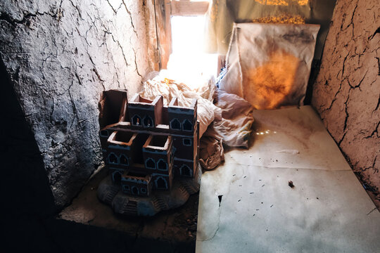 Traditional clay model of a ksar from ait ben haddou, morocco, displayed indoors with natural light coming from an opening