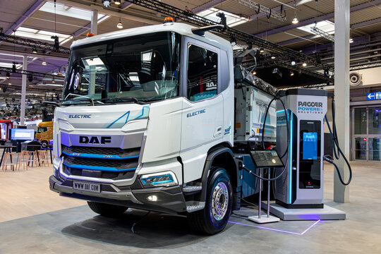 DAF XDC 270e electric construction truck for heavy-duty transport and off-road applications connected to a charging station.