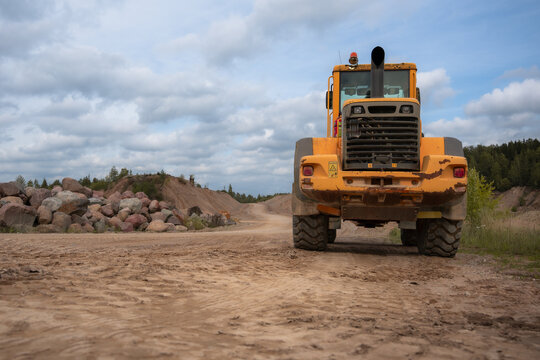 Yellow wheel loader on a dirt road at a sand and gravel quarry