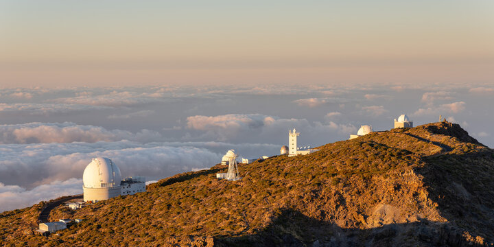 Panoramic view of Roque de los Muchachos Observatory domes above clouds at sunset, La Palma