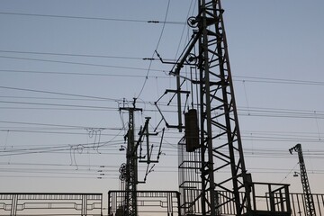 Vue en perspective d'un pylône électrique en ossature métallique, portant des lignes à haute tension. Structure dédiée au transport de l'énergie par voie aérienne. Ciel bleu en arrière plan. © Xavier