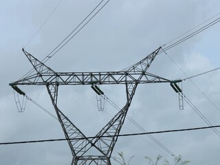 Vue en perspective d'un pylône électrique en ossature métallique, portant des lignes à haute tension. Structure dédiée au transport de l'énergie par voie aérienne. Ciel bleu en arrière plan. © Xavier
