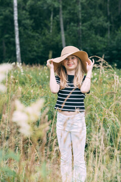 Girl with hat in field