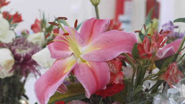 Close up of vibrant pink Stargazer lily blooming in colorful floral bouquet