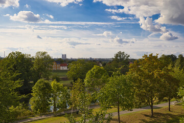 Obraz premium Weitblick vom Kurpark in Bad Dürrenberg über grüne Wiesen und Häuser auf den Chemiepark Leuna am Horizont mit bewölktem Himmel, Saalekreis, Sachsen-Anhalt, Deutschland
