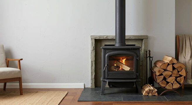 Modern cast iron wood burning stove in living room. Heating system theme