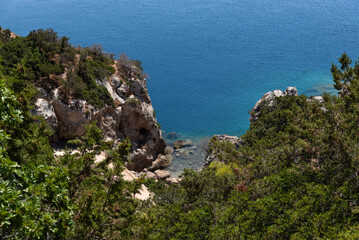 Fototapeta premium Beautiful view from above of the blue sea and cliffs on a sunny day. The city of Loutraki, Greece. Mediterranean landscape.