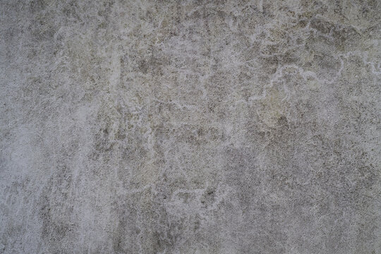 Light grey rendered wall texture with mottled weathering and irregular aged surface
