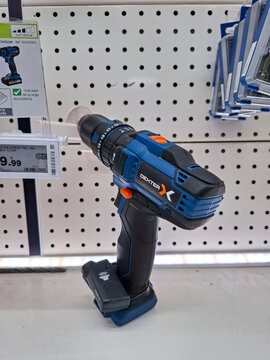 Denia, Spain - October 10, 2025. Dexter cordless drill displayed for sale on a white pegboard shelf in a hardware store in Spain