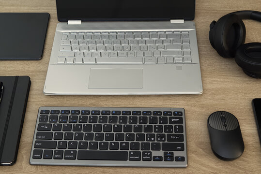 Complete modern workspace setup with laptop, external keyboard, and headphones