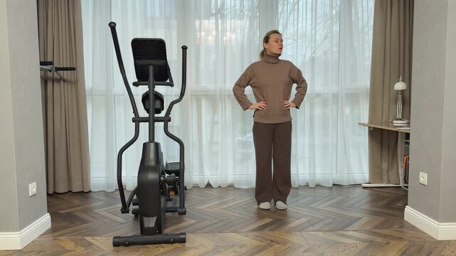 Woman in sports top, leggings and sneakers runs in place at high speed in living room. Intense home cardio training.