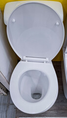 Top down view of a white ceramic toilet with open lid in a bathroom setting for home renovation...