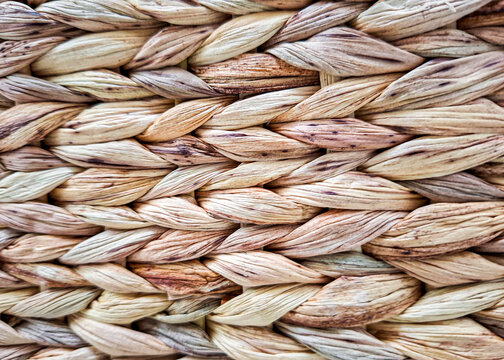 Handmade straw basket made from thick natural dried grass strands woven into a tight herringbone pattern