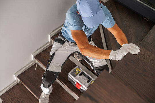 Worker checking a panel beside an indoor staircase