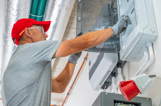 Electrician working at an open electrical panel