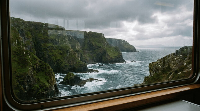 Scenic view of Irish coastal cliffs through a train window for travel content and tourism marketing