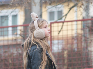 Profile Side View Of Young Girl Wearing Fluffy Earmuffs In Autumn © Kata