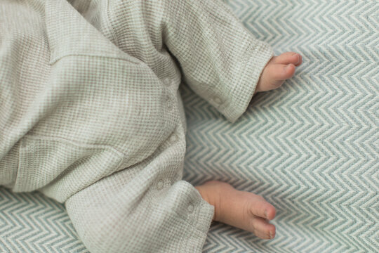 Newborn Baby Boy feet in a cute little knitted outfit on a blanket