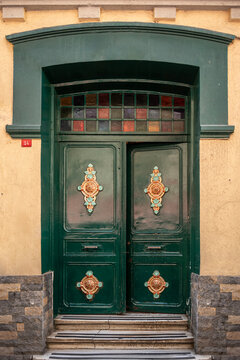 Elegant green wooden historic door with golden ornaments and stained glass windows in Istanbul. 